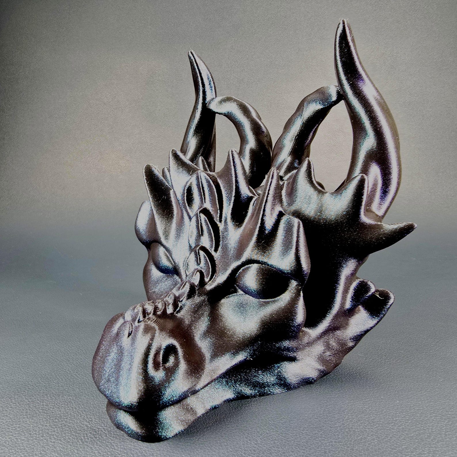 Close-up of the 3D printed dragon glasses holder showing the printed texture and frame support area